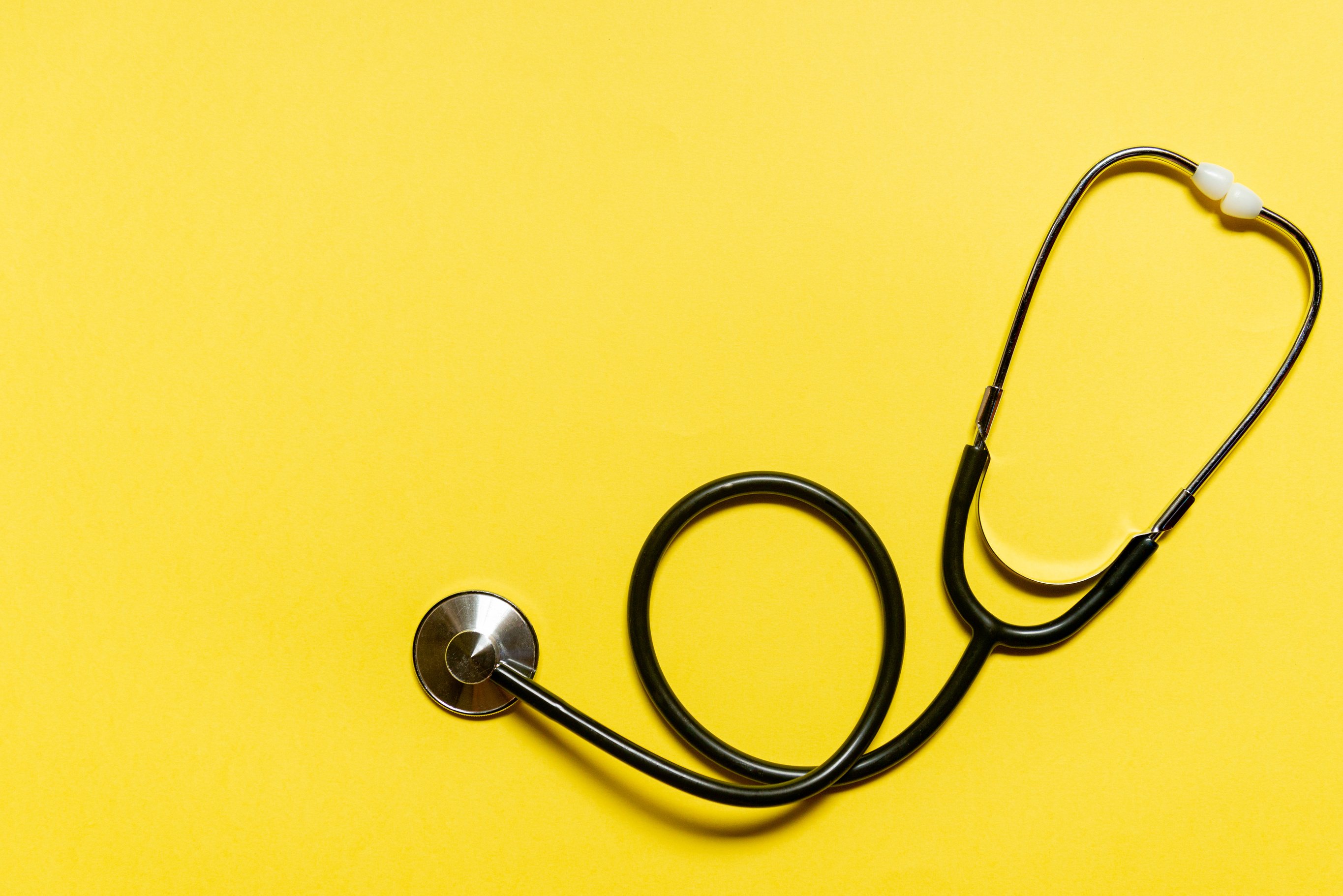 Stethoscope on yellow background. Heart check or health check concept